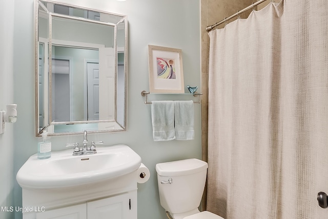 bathroom with vanity, toilet, and curtained shower