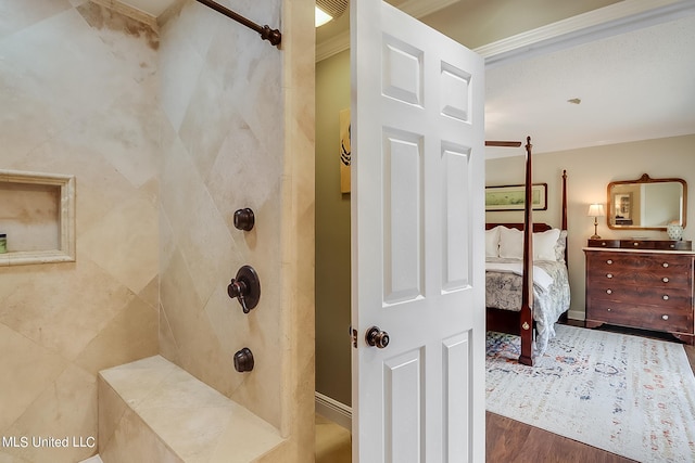 bathroom with a tile shower, wood-type flooring, and ornamental molding