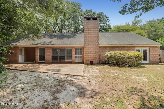 rear view of house with a patio area and a lawn