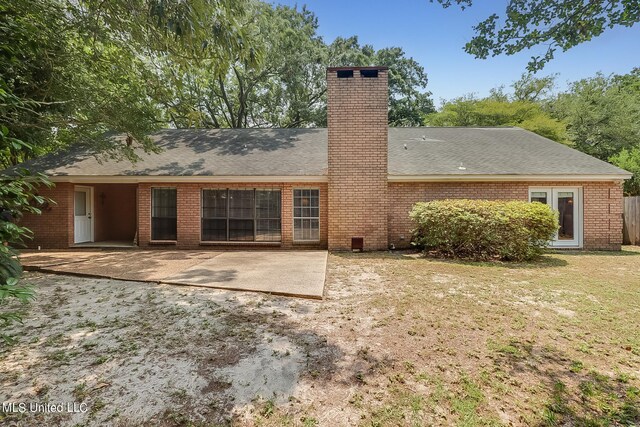 back of property with a patio area and a lawn