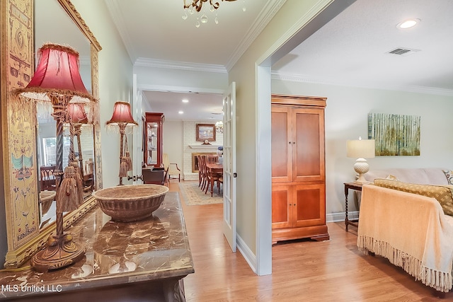 hallway with light hardwood / wood-style flooring and ornamental molding