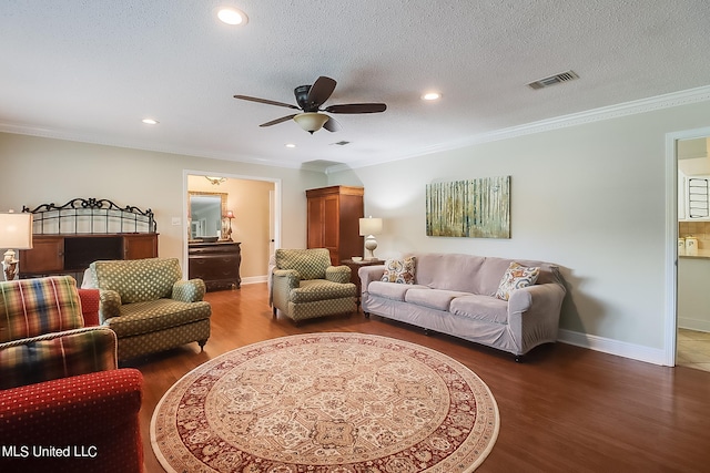 living room featuring dark wood-type flooring, crown molding, a textured ceiling, and ceiling fan