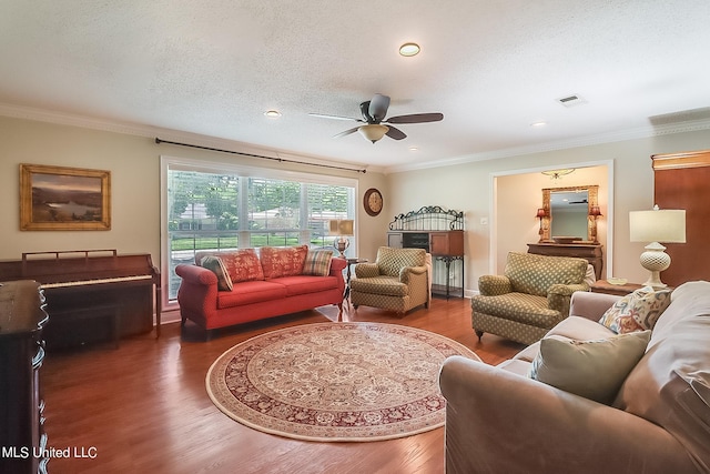 living room with ornamental molding, dark wood-type flooring, a textured ceiling, and ceiling fan