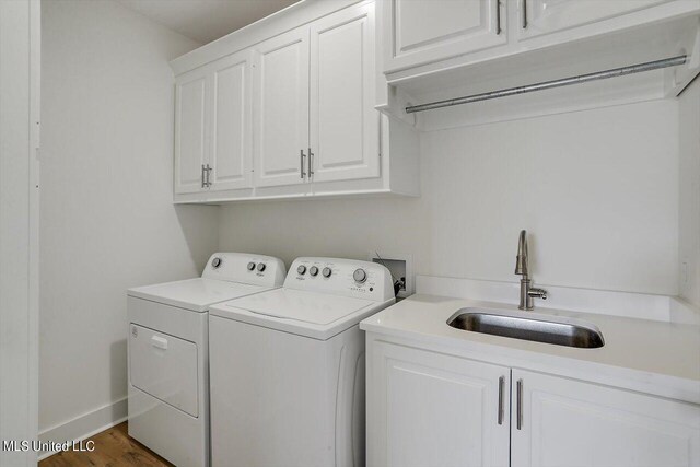 washroom with cabinets, dark hardwood / wood-style floors, sink, and separate washer and dryer