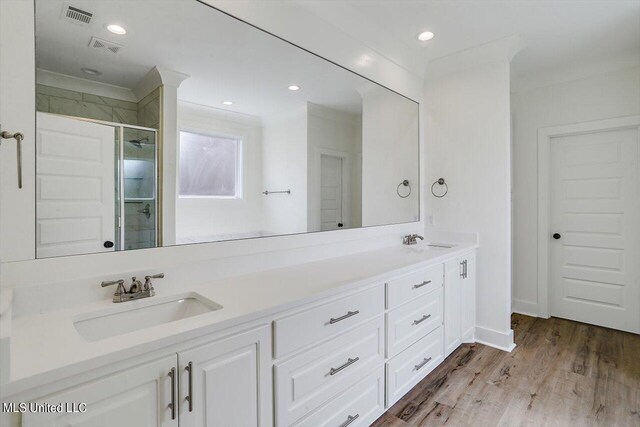 bathroom with vanity, hardwood / wood-style floors, and a shower with door