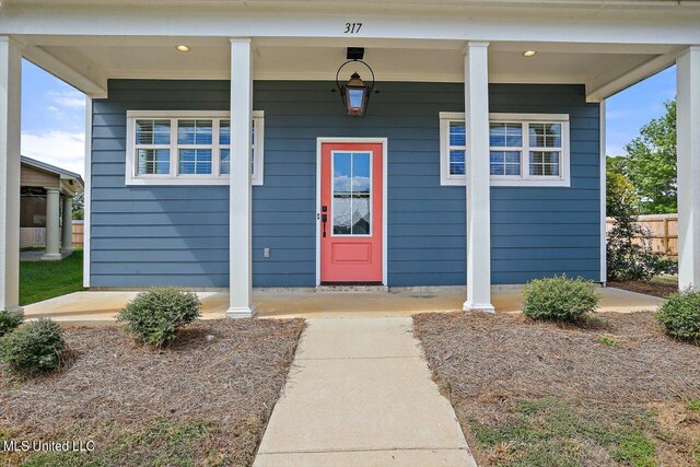 view of exterior entry with a porch