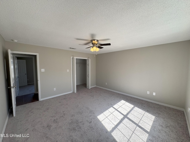 unfurnished bedroom featuring a closet, ceiling fan, light colored carpet, and a textured ceiling