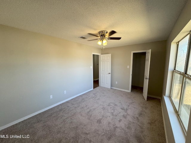 unfurnished bedroom featuring ceiling fan, carpet floors, and a textured ceiling