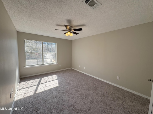 carpeted empty room featuring ceiling fan and a textured ceiling