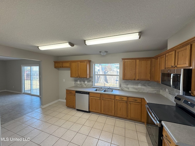 kitchen with tasteful backsplash, sink, stainless steel appliances, and light tile patterned flooring