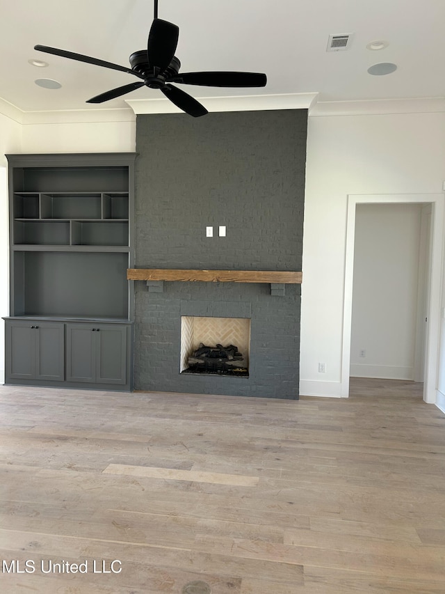 unfurnished living room with a fireplace, light hardwood / wood-style floors, ceiling fan, and crown molding