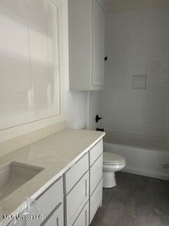 full bathroom featuring washtub / shower combination, vanity, and toilet