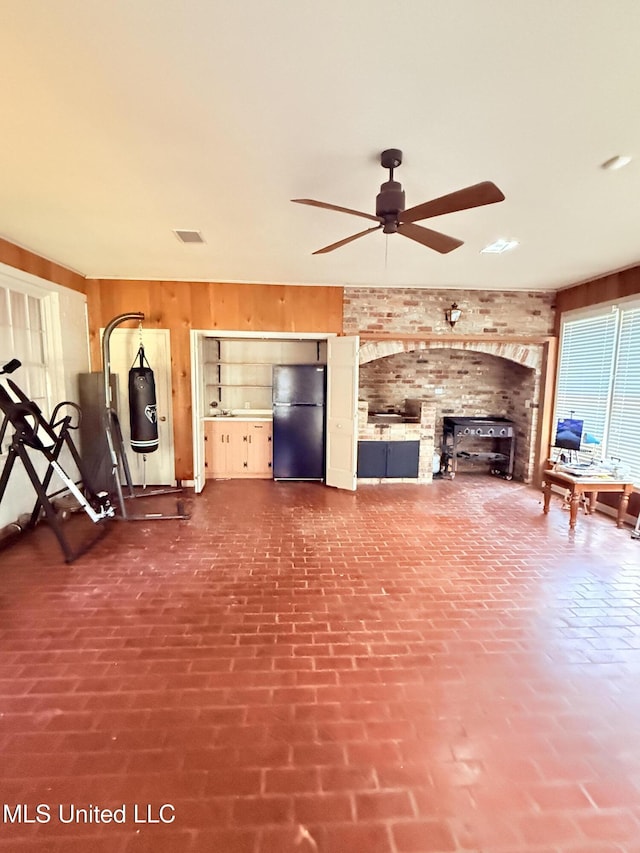 820 Ave Of Pines St, Grenada, MS 38901 - unfurnished living room featuring wooden walls and ceiling fan