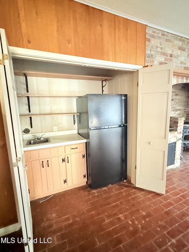 820 Ave Of Pines St, Grenada, MS 38901 - kitchen featuring brick wall, black refrigerator, and sink