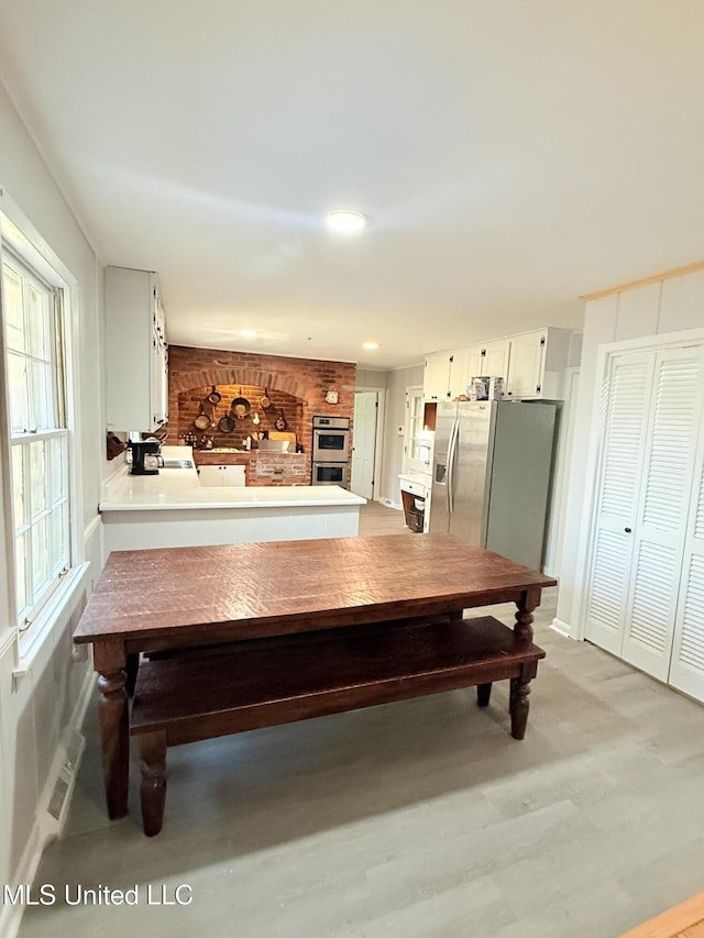 820 Ave Of Pines St, Grenada, MS 38901 - dining room with a fireplace and light hardwood / wood-style floors