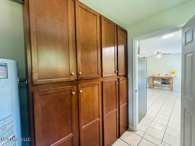 113 Richardson Rd, Picayune, MS 39466 - hallway featuring light tile patterned flooring, water heater, and a textured ceiling