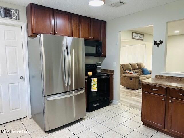 113 Richardson Rd, Picayune, MS 39466 - kitchen featuring black appliances, dark countertops, light tile patterned floors, and open floor plan
