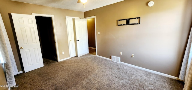 unfurnished bedroom with carpet flooring, baseboards, a ceiling fan, and visible vents