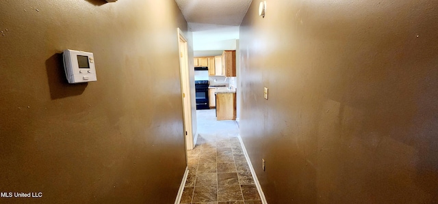 hall with baseboards and stone finish floor