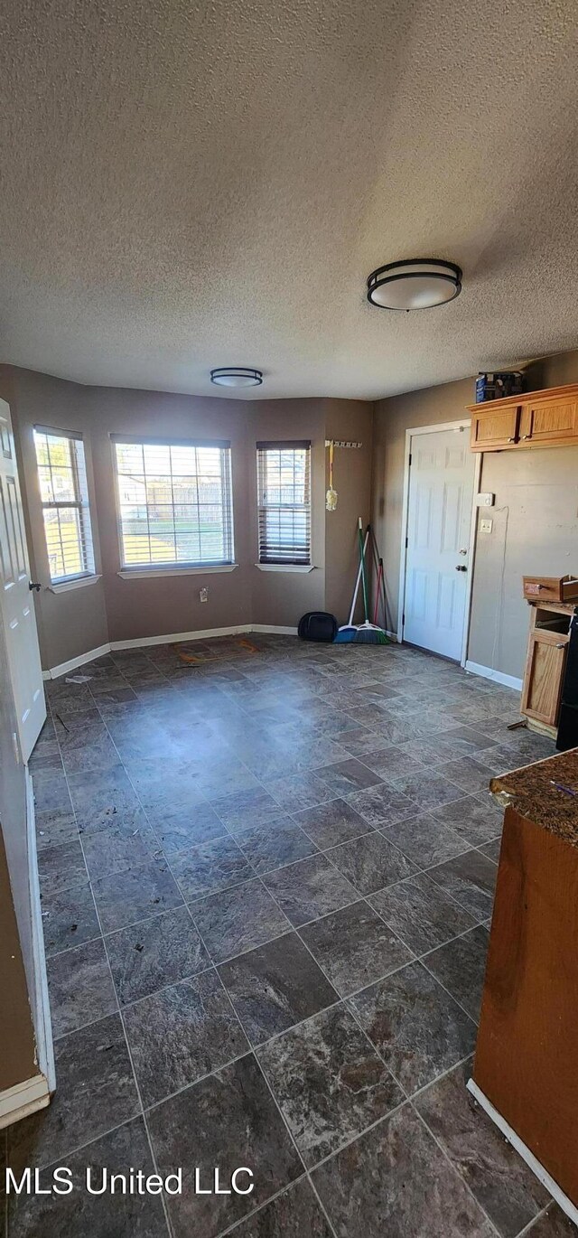 interior space with baseboards and a textured ceiling
