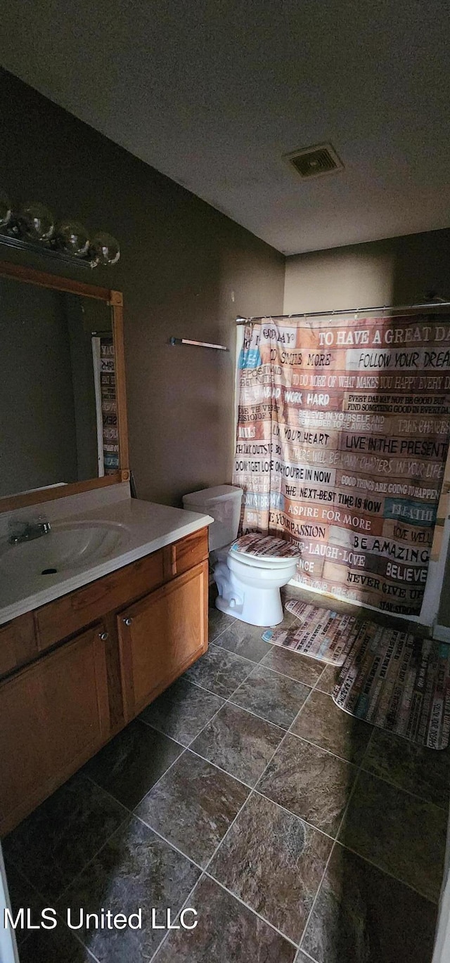 bathroom featuring visible vents, toilet, vanity, and a shower with curtain
