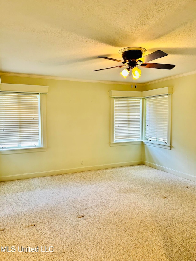 empty room featuring ceiling fan, a healthy amount of sunlight, a textured ceiling, and crown molding