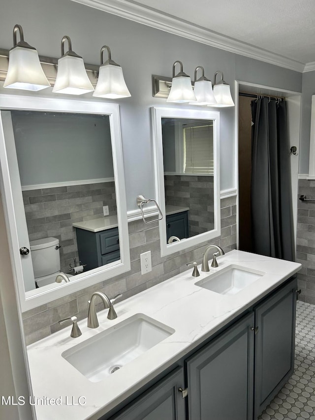 bathroom featuring toilet, tile patterned flooring, vanity, ornamental molding, and tile walls