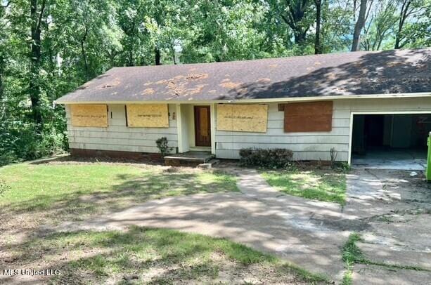 ranch-style house featuring an attached garage and driveway