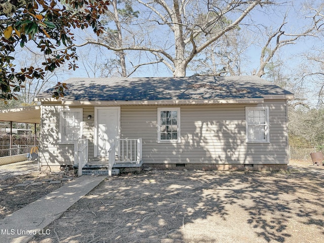 view of front facade with roof with shingles, crawl space, and fence