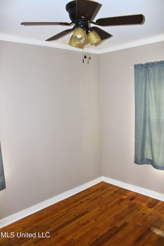 empty room with ceiling fan, baseboards, crown molding, and wood finished floors