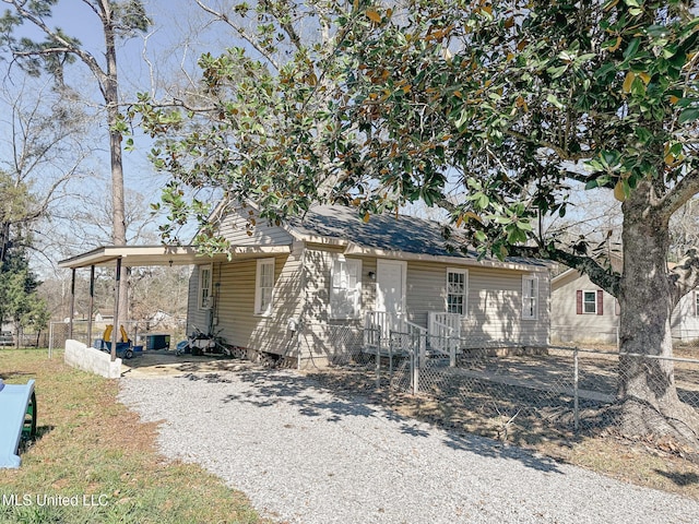 view of front of home with driveway, fence, and a carport