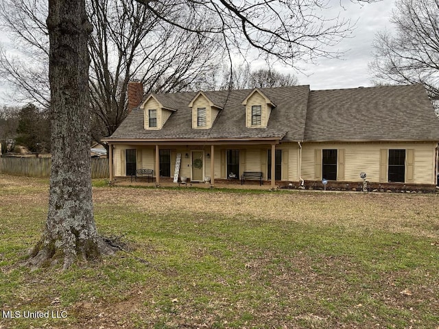 cape cod house featuring covered porch, a chimney, fence, and a front yard