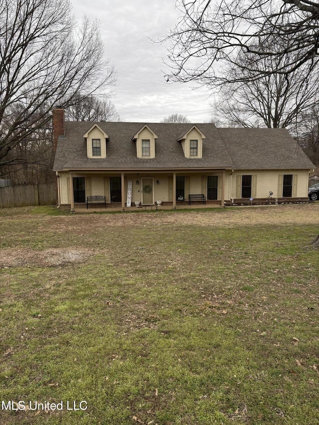 cape cod-style house featuring a front yard and a shingled roof