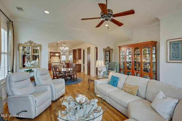 living room featuring crown molding, ceiling fan with notable chandelier, and light wood-type flooring