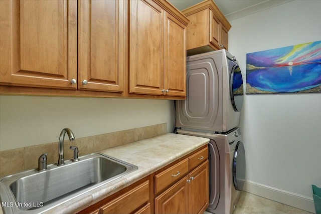 laundry room featuring sink, cabinets, and stacked washing maching and dryer