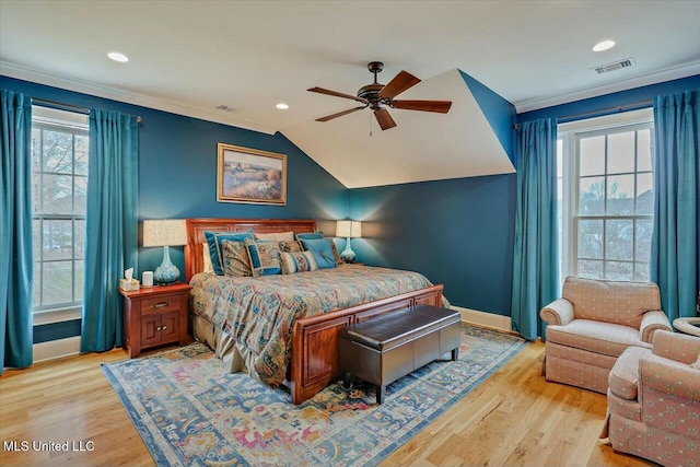 bedroom featuring ceiling fan, ornamental molding, lofted ceiling, and light wood-type flooring