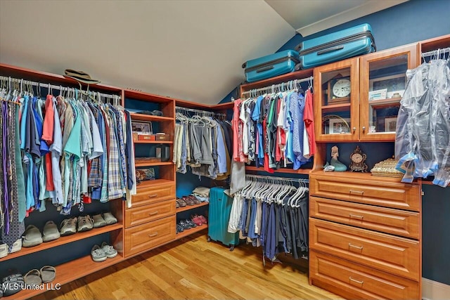 walk in closet featuring vaulted ceiling and light wood-type flooring