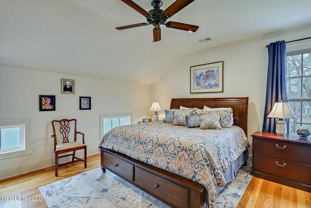 bedroom with ceiling fan, lofted ceiling, and light hardwood / wood-style floors