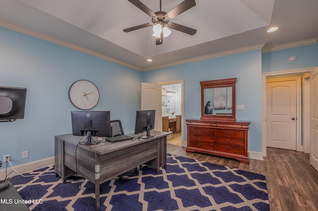 office area with dark wood-type flooring, a ceiling fan, baseboards, ornamental molding, and a raised ceiling