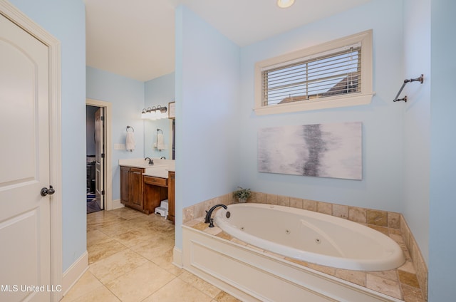 bathroom featuring tile patterned flooring, a jetted tub, vanity, and baseboards