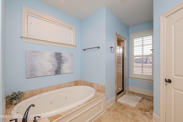 bathroom with a jetted tub, a shower stall, baseboards, and tile patterned floors