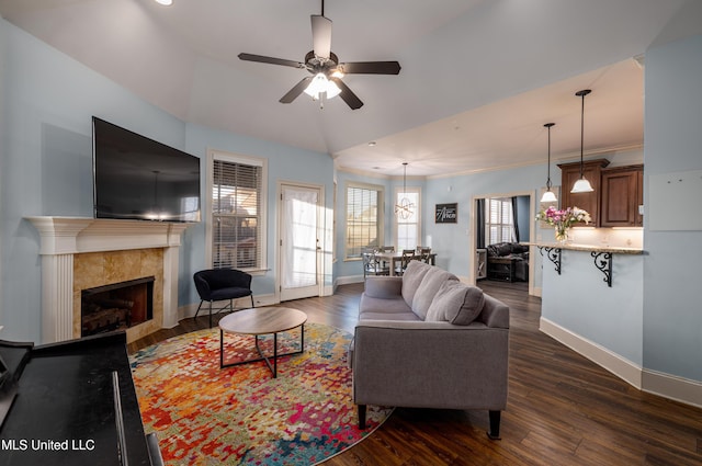 living room with dark wood-style floors, ceiling fan, a fireplace, and baseboards