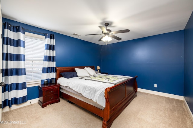 bedroom with light carpet, ceiling fan, visible vents, and baseboards