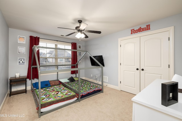 bedroom with ceiling fan, light colored carpet, visible vents, baseboards, and a closet