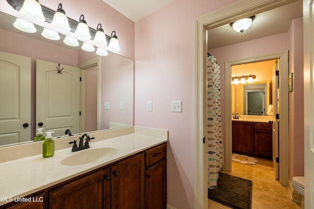 bathroom with toilet, tile patterned flooring, and vanity