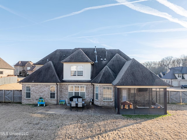 rear view of house featuring a patio, roof with shingles, a fenced backyard, and a sunroom