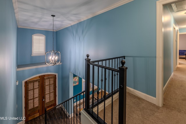 interior space with ornamental molding, carpet flooring, a notable chandelier, and baseboards