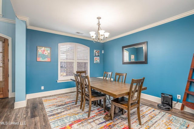 dining space with visible vents, baseboards, wood finished floors, crown molding, and a notable chandelier