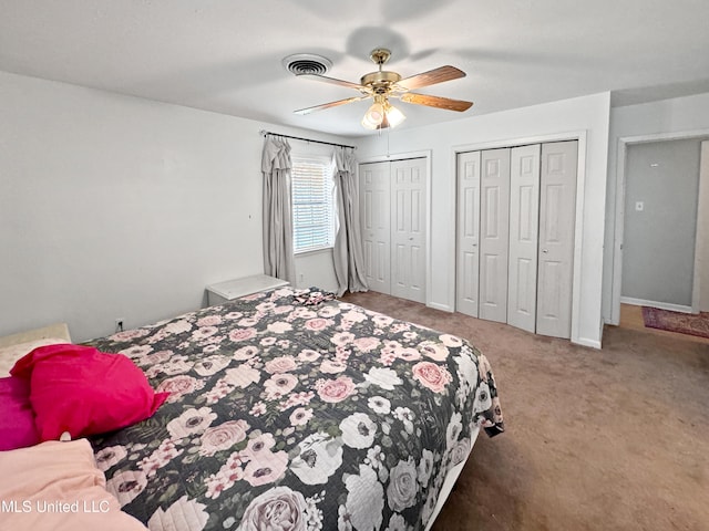 bedroom with two closets, carpet flooring, and ceiling fan