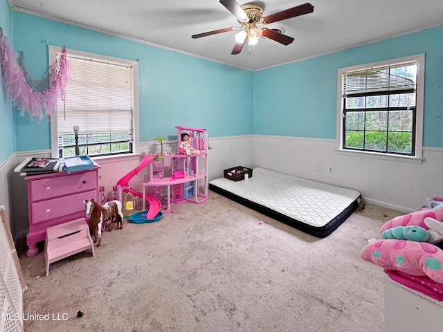 bedroom with ornamental molding, carpet flooring, multiple windows, and ceiling fan